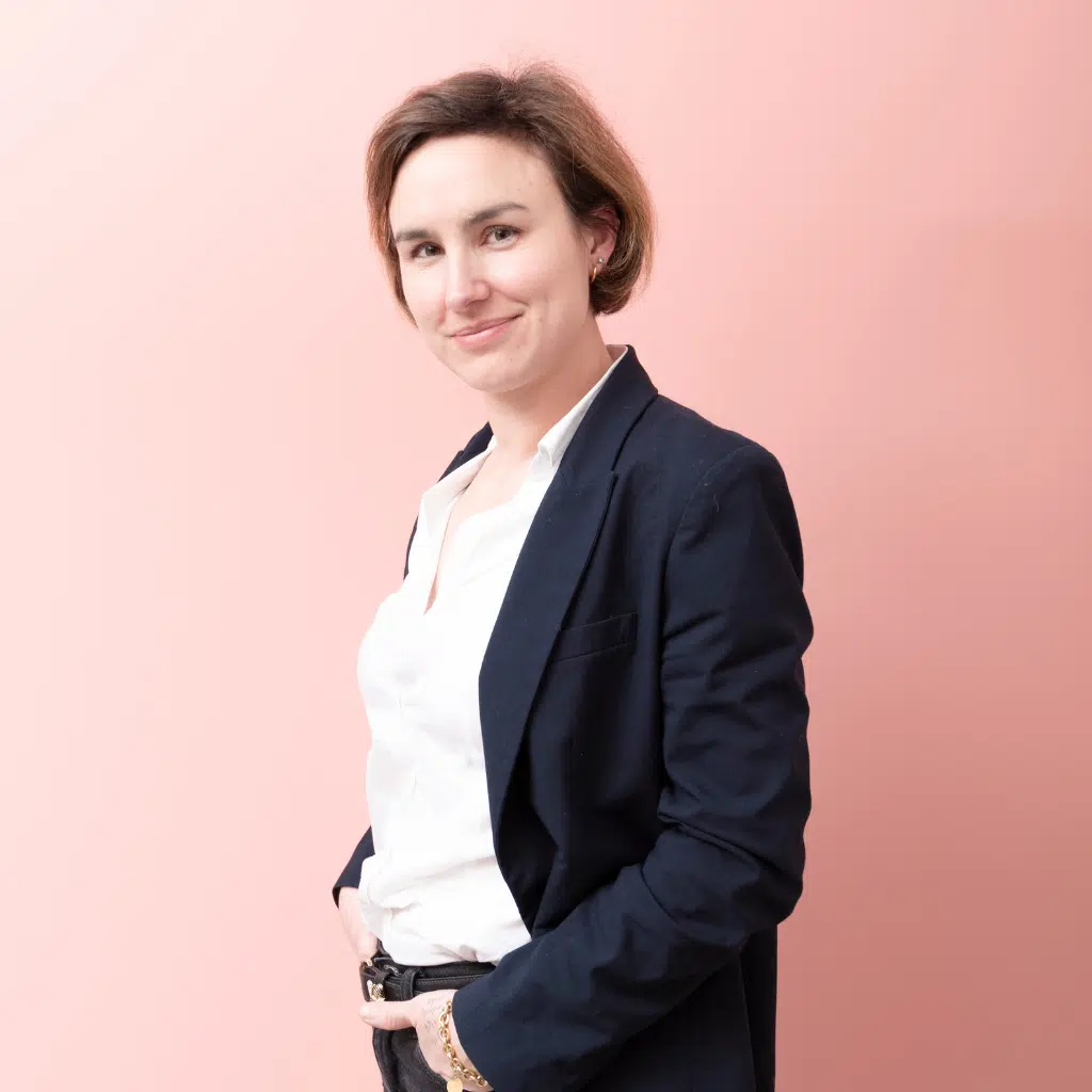 Photo d'Anne Tissier Cabaret, avocate en droit des successions, blonde la trentaine sur fond rose.